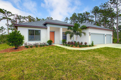 Large modern white one-story stucco house exterior idea in Orlando with a hip roof and a shingle roof