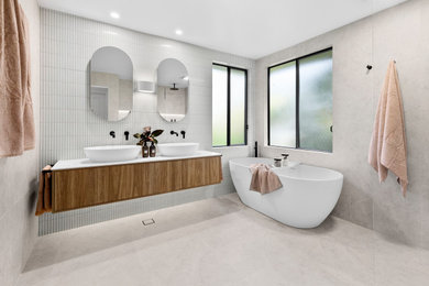 Design ideas for a large contemporary master bathroom in Sydney with furniture-like cabinets, medium wood cabinets, a freestanding tub, an open shower, a one-piece toilet, multi-coloured tile, porcelain tile, multi-coloured walls, porcelain floors, a vessel sink, solid surface benchtops, multi-coloured floor, an open shower, white benchtops, a niche, a double vanity and a floating vanity.