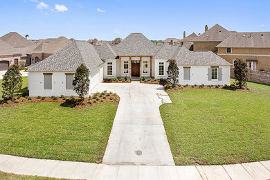 Example of a mid-sized classic white one-story brick exterior home design in New Orleans with a hip roof