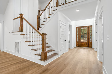 Example of a mid-sized classic vinyl floor and brown floor entryway design in Raleigh with white walls and a medium wood front door