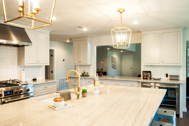 Inspiration for a mid-sized contemporary l-shaped medium tone wood floor open concept kitchen remodel in Other with white cabinets, an island, shaker cabinets, marble countertops, subway tile backsplash, stainless steel appliances and white backsplash