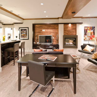 Contemporary look-out basement in Vancouver with white walls, light hardwood flooring, a standard fireplace, a metal fireplace surround and beige floors.