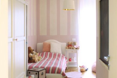 ミラノにある高級な広いシャビーシック調のおしゃれな子供部屋 (ピンクの壁、淡色無垢フローリング、児童向け、茶色い床) の写真