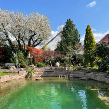 Schwimmteich mit Wasserfall, Sitzplatz und Stegterrasse