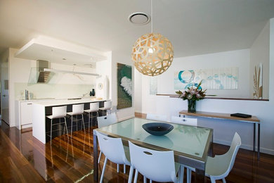 Mid-sized contemporary open plan dining in Sunshine Coast with white walls, medium hardwood floors and no fireplace.