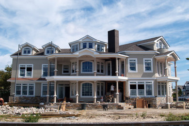 Example of a large beach style brown three-story wood and shingle exterior home design in Other
