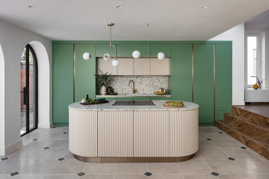 Contemporary galley kitchen in London with a submerged sink, flat-panel cabinets, green cabinets, terrazzo worktops, integrated appliances, an island, beige floors and multicoloured worktops.