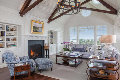 Beach style enclosed family room in Boston with white walls, dark hardwood floors, a standard fireplace, a metal fireplace surround and brown floor.