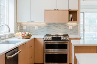 Kitchen - mid-sized transitional l-shaped medium tone wood floor and brown floor kitchen idea in Baltimore with an undermount sink, flat-panel cabinets, light wood cabinets, quartz countertops, blue backsplash, ceramic backsplash, stainless steel appliances, an island and white countertops