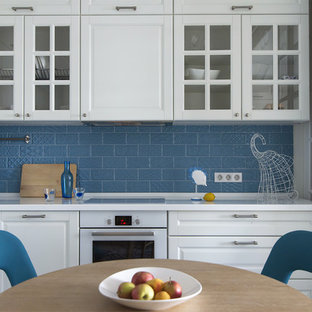 Неиссякаемый источник вдохновения для домашнего уюта: маленькая угловая кухня-гостиная в современном стиле с фасадами с выступающей филенкой, белыми фасадами, столешницей из акрилового камня, синим фартуком, фартуком из керамической плитки, белой техникой, полом из керамической плитки, синим полом и накладной раковиной без острова