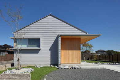 Imagen de fachada de casa gris y gris minimalista de una planta con tejado a dos aguas y tejado de metal