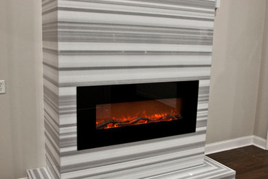 Inspiration for a dark wood floor and brown floor family room remodel in Atlanta with beige walls and a stone fireplace