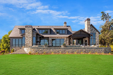 Large contemporary gray two-story stone exterior home idea in Other with a shingle roof and a gray roof