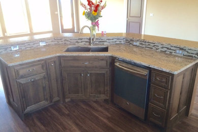 Kitchen pantry - mid-sized eclectic kitchen pantry idea in Little Rock with an undermount sink, recessed-panel cabinets, dark wood cabinets, laminate countertops, beige backsplash, glass tile backsplash, stainless steel appliances and an island
