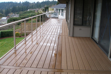This is an example of a mid-sized traditional backyard patio in Seattle with decking and a roof extension.