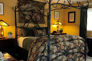 Ejemplo de dormitorio principal bohemio pequeño sin chimenea con parades naranjas, suelo de madera oscura y suelo marrón