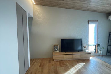 Diseño de salón abierto y beige de tamaño medio con paredes beige, suelo de madera clara, televisor independiente, papel pintado y papel pintado