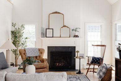 Living room - transitional light wood floor, beige floor and vaulted ceiling living room idea in Boston with white walls, a standard fireplace and a tile fireplace
