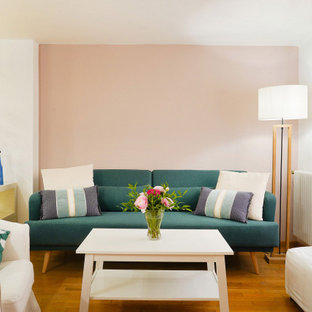 Ispirazione per un piccolo soggiorno design aperto con pareti rosa, pavimento in legno massello medio e pavimento marrone