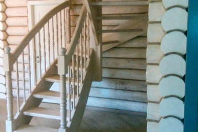 Photo of a transitional wood u-shaped staircase in Moscow with wood railing.