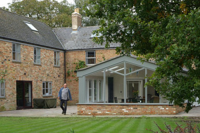 Diseño de fachada de casa gris y gris tradicional grande de dos plantas con revestimiento de madera, tejado a dos aguas y tejado de teja de barro