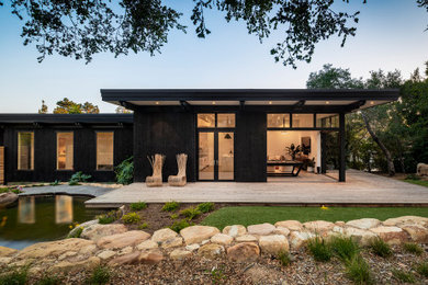 Design ideas for a mid-sized midcentury one-storey black house exterior in Santa Barbara with a flat roof.