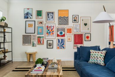 Inspiration for a large contemporary open concept light wood floor and beige floor living room remodel in Tampa with white walls