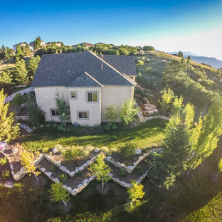 Großer, Halbschattiger Stilmix Hanggarten im Sommer mit Gartenmauer und Mulch in Denver