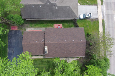 Foto de fachada de casa marrón actual de tamaño medio de una planta con revestimiento de ladrillo, tejado a dos aguas y tejado de teja de madera