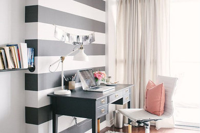 Example of a mid-sized minimalist freestanding desk dark wood floor study room design in New York with black walls