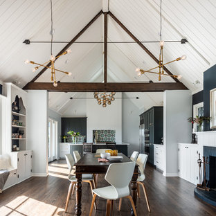 シアトルの広いカントリー風 LDKの画像 (濃色無垢フローリング、標準型暖炉、青い壁、レンガの暖炉まわり、茶色い床)