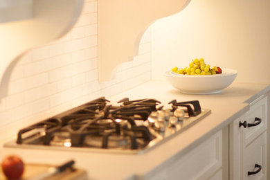 Elegant dark wood floor eat-in kitchen photo in Kansas City with shaker cabinets, white cabinets, white backsplash, ceramic backsplash and stainless steel appliances