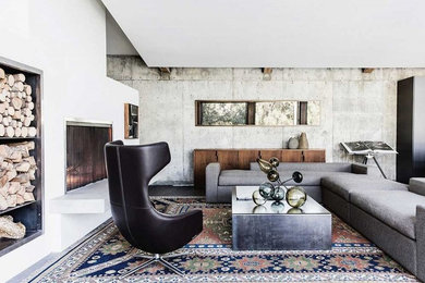 Inspiration for a large industrial enclosed family room remodel in San Francisco with white walls, a standard fireplace, a plaster fireplace and no tv