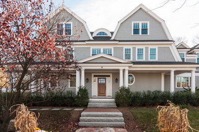 Large ornate gray three-story wood house exterior photo in Boston with a gambrel roof and a shingle roof