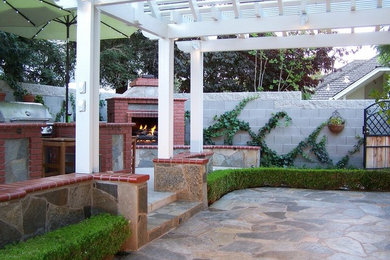 Design ideas for a large contemporary backyard patio in Other with an outdoor kitchen, natural stone pavers and a pergola.