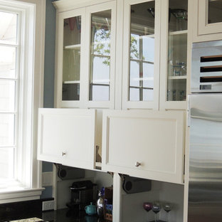 This is an example of a mid-sized contemporary l-shaped kitchen pantry in Other with a double-bowl sink, flat-panel cabinets, white cabinets, blue splashback, subway tile splashback, stainless steel appliances, medium hardwood floors and with island.