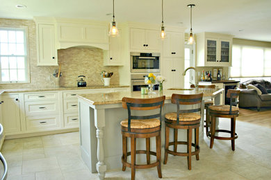 Eat-in kitchen - large craftsman l-shaped porcelain tile and beige floor eat-in kitchen idea in Boston with shaker cabinets, stone tile backsplash, an undermount sink, white cabinets, granite countertops, beige backsplash, stainless steel appliances and an island