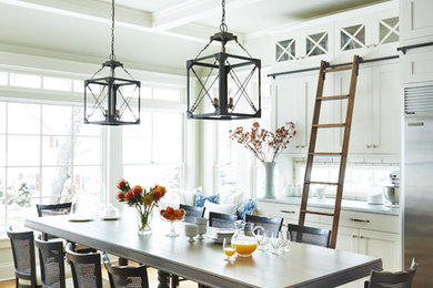 Beach style galley medium tone wood floor kitchen photo in Milwaukee with shaker cabinets, white cabinets, stainless steel appliances and an island