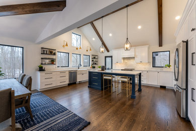 Inspiration for a large transitional medium tone wood floor and exposed beam eat-in kitchen remodel in Cleveland with an undermount sink, shaker cabinets, quartzite countertops, white backsplash, marble backsplash, stainless steel appliances, an island and white countertops