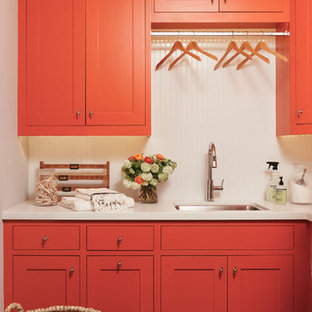 Imagen de lavadero multiusos y en L, campestre, de tamaño medio, con fregadero bajoencimera, encimera de cuarzo compacto, paredes blancas, suelo de pizarra, lavadora y secadora juntas, armarios estilo shaker y puertas de armario rojas