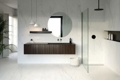 Aménagement d'une salle de bain principale moderne en bois foncé de taille moyenne avec un placard à porte plane, une douche à l'italienne, un carrelage blanc, un sol en carrelage de céramique, un plan de toilette noir, meuble simple vasque et meuble-lavabo suspendu.