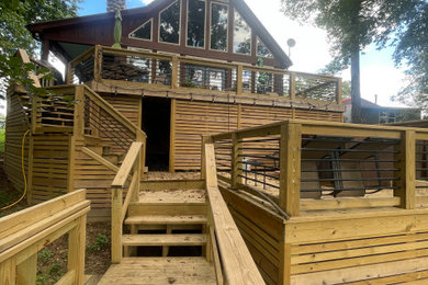 Inspiration for a large rustic backyard ground level wood railing deck remodel in Little Rock with no cover