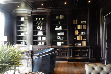 Inspiration for a large traditional study room in Surrey with black walls, dark hardwood floors, a standard fireplace, a stone fireplace surround, a freestanding desk and brown floor.