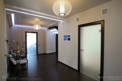 На фото: коридор среднего размера в современном стиле с белыми стенами, полом из керамогранита и коричневым полом