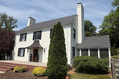 Elegant white two-story exterior home photo in Other with a shingle roof and a gray roof