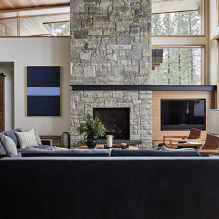 Idéer för att renovera ett funkis allrum med öppen planlösning, med vita väggar, mellanmörkt trägolv, en standard öppen spis, en väggmonterad TV och brunt golv