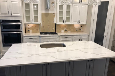 Gray floor eat-in kitchen photo in Raleigh with a single-bowl sink, quartz countertops, stainless steel appliances, an island and white countertops