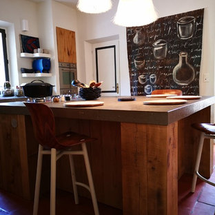 Неиссякаемый источник вдохновения для домашнего уюта: маленькая угловая кухня-гостиная в стиле кантри с монолитной раковиной, светлыми деревянными фасадами, столешницей из гранита, техникой из нержавеющей стали, полом из терракотовой плитки, островом, розовым полом и серой столешницей