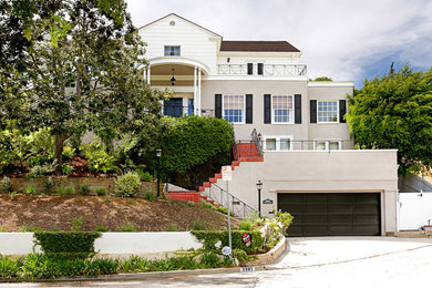 Large traditional beige three-story stucco exterior home idea in Los Angeles with a shingle roof