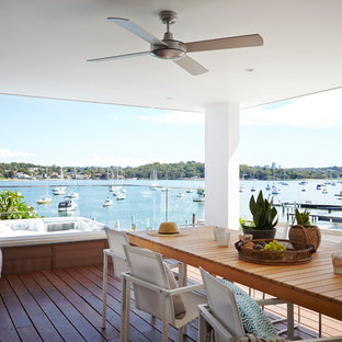 Contemporary back terrace and balcony in Sydney with a roof extension.